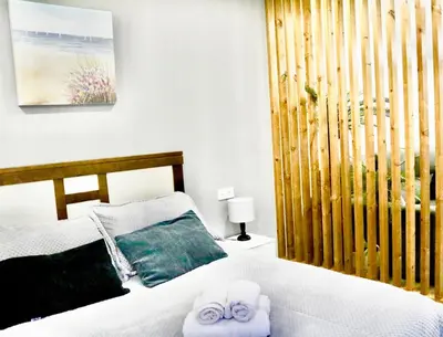 a bedroom with a bed with two towels on it at Atico Deluxe Limosa romántico moderno junto al mar in San Ciprián