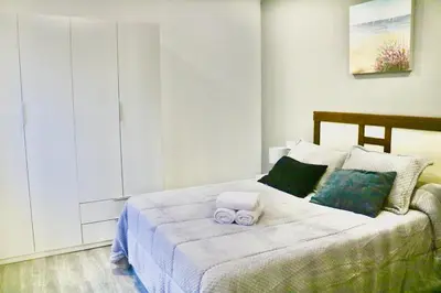 a bedroom with a bed with two towels on it at Atico Deluxe Limosa romántico moderno junto al mar in San Ciprián