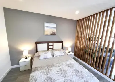 a bedroom with a bed with two lamps and a window at Atico Deluxe Limosa romántico moderno junto al mar in San Ciprián