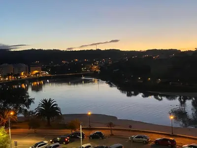 a view of a river with cars parked in a parking lot at Atico Deluxe Limosa romántico moderno junto al mar in San Ciprián