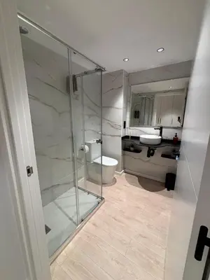 a bathroom with a glass shower and a sink at Tinería Lux in Lugo