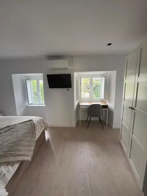 a bedroom with a bed and a desk and windows at Tinería Lux in Lugo