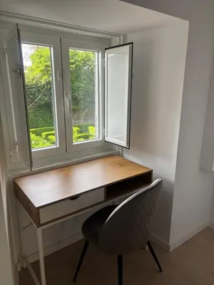a desk and a chair in a room with a window at Tinería Lux in Lugo