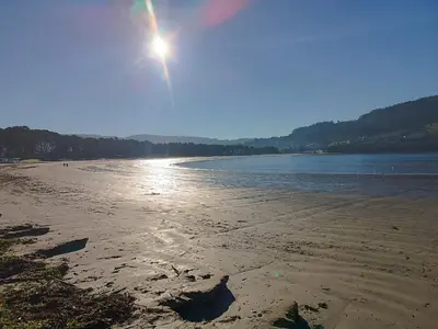 a beach with the sun shining on the sand at La Favorita de Cabanas in Cabañas