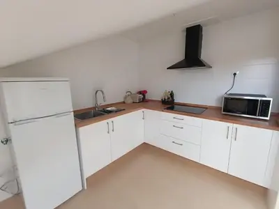 a kitchen with white cabinets and a microwave at La Favorita de Cabanas in Cabañas