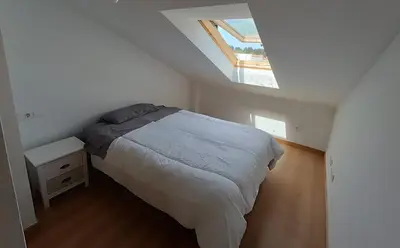 a small bedroom with a bed and a skylight at La Favorita de Cabanas in Cabañas