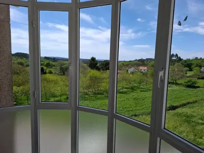 a window view of a field from a house at Road in Palas de Rei