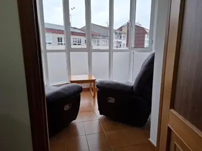 two chairs sitting in a room with windows at Road in Palas de Rei
