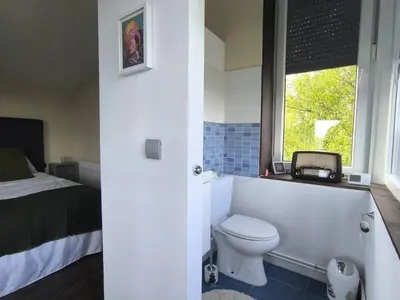 a bathroom with a toilet and a bed and a window at Relax & Vistas, casa en la roca in Rogüela