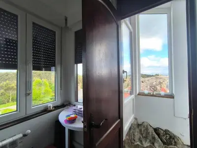 a bathroom with a sink and two windows and a door at Relax & Vistas, casa en la roca in Rogüela