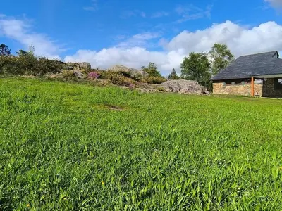 a field of green grass next to a building at Relax & Vistas, casa en la roca in Rogüela