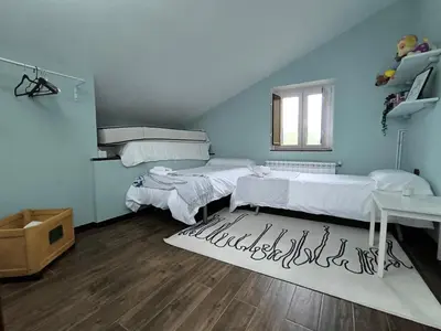 two beds in a blue room with a rug at Relax & Vistas, casa en la roca in Rogüela
