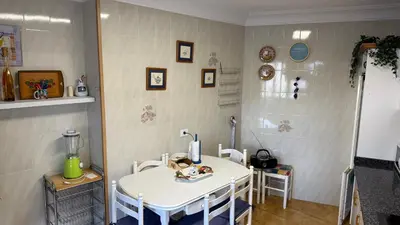 a kitchen with a white table and chairs in a room at Piso vacacional en Ribadeo in Ribadeo