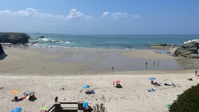 people on a beach with umbrellas in the sand at Piso vacacional en Ribadeo in Ribadeo