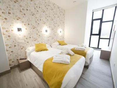 a room with two beds with towels on them at Pensión Spa Cruceiro de Pedrouzo in O Pedrouzo
