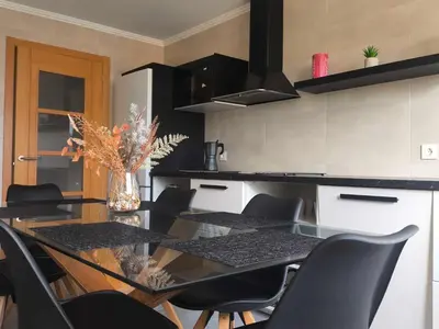 a kitchen with a glass table and black chairs at Xabarin Apart II in Abadín