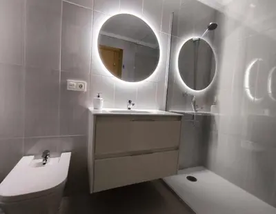 a bathroom with a sink and a mirror and a toilet at Xabarin Apart II in Abadín