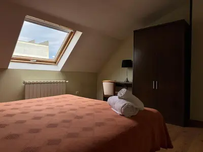 a bedroom with a large bed and a window at Pensión Restaurante Tino in Germade
