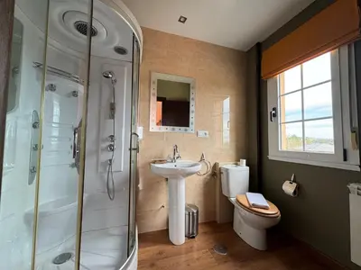 a bathroom with a sink and a shower and a toilet at Pensión Restaurante Tino in Germade