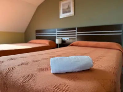 a towel on a bed in a room at Pensión Restaurante Tino in Germade