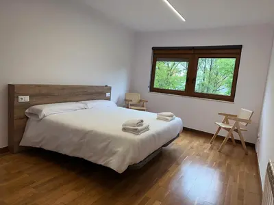 a bedroom with a large bed and a window at Pensión Río Sarria in Sarria