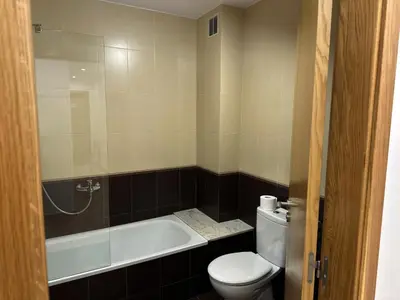 a bathroom with a toilet and a tub and a sink at Pensión Río Sarria in Sarria