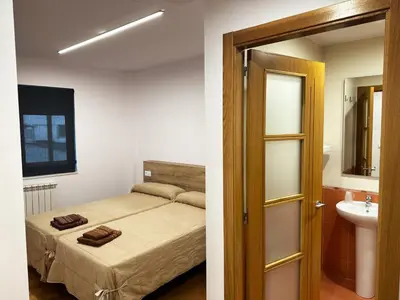 a small bedroom with a bed and a bathroom at Pensión Río Sarria in Sarria
