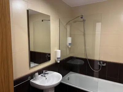 a bathroom with a sink and a mirror and a tub at Pensión Río Sarria in Sarria
