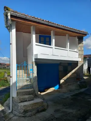 a small house with a balcony on top of it at A casa da Cernada in Rocas
