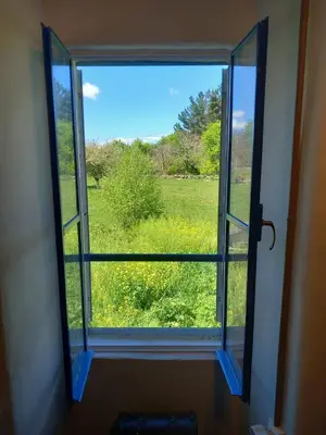 an open window with a view of a field at A casa da Cernada in Rocas