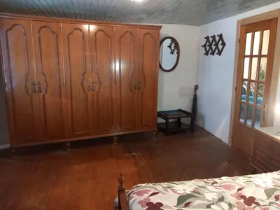 a bedroom with a large wooden wardrobe and a bed at A casa da Cernada in Rocas