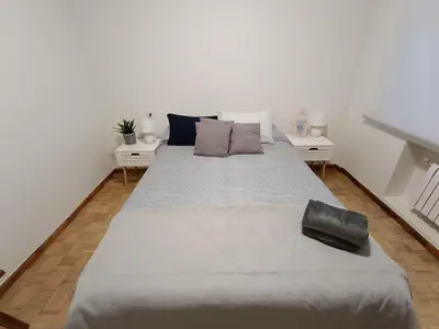 a large bed in a room with two tables at A Torre in Ribadeo