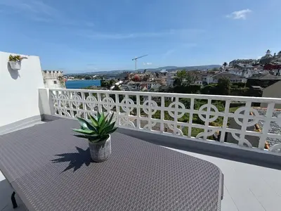 a table on a balcony with a potted plant at A Torre in Ribadeo