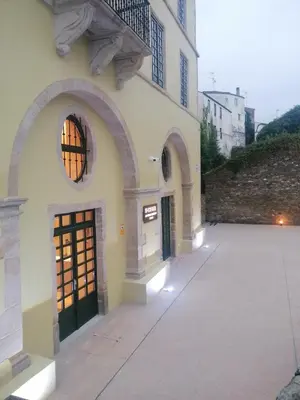 a white building with a door and a balcony at U-Hotel Aduana Ribadeo in Ribadeo