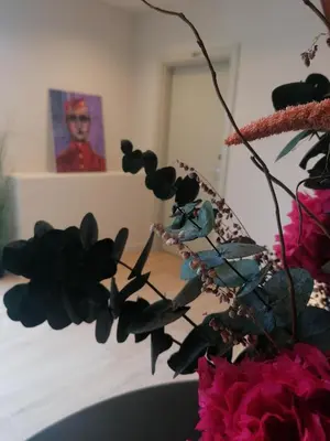 a vase with flowers and a picture of a woman at U-Hotel Aduana Ribadeo in Ribadeo