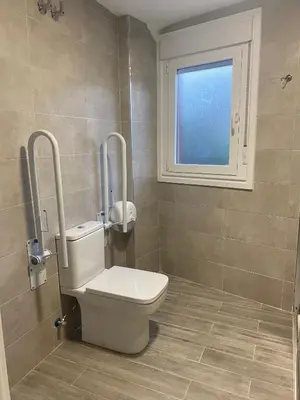 a bathroom with a toilet and a window at Albergue o Bailarin in O Barco de Valdeorras