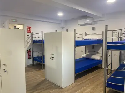 a room with three bunk beds and a hallway at Albergue o Bailarin in O Barco de Valdeorras