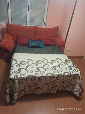 a large bed in a room with red pillows at La Niña in Tineo