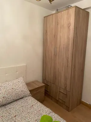 a bedroom with a bed and a wooden cabinet at Casa centro histórico de Viveiro in Viveiro