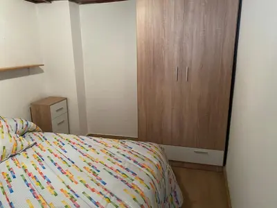 a bedroom with a bed and a wooden cabinet at Casa centro histórico de Viveiro in Viveiro