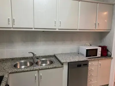 a kitchen with a sink and a microwave at Casa centro histórico de Viveiro in Viveiro
