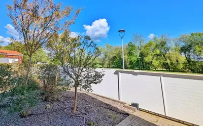 a white fence with a tree and a street light at Casa con piscina Riosar Santiago in Amés