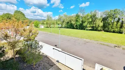 an empty parking lot with trees and a field at Casa con piscina Riosar Santiago in Amés