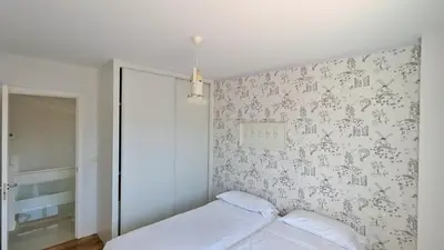 a bedroom with a bed and a wall with wallpaper at Casa con piscina Riosar Santiago in Amés