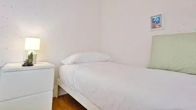 a bedroom with a white bed and a lamp on a night stand at Casa con piscina Riosar Santiago in Amés