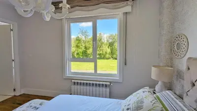 a bedroom with a bed and a window at Casa con piscina Riosar Santiago in Amés
