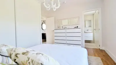 a white bedroom with a bed and a sink at Casa con piscina Riosar Santiago in Amés