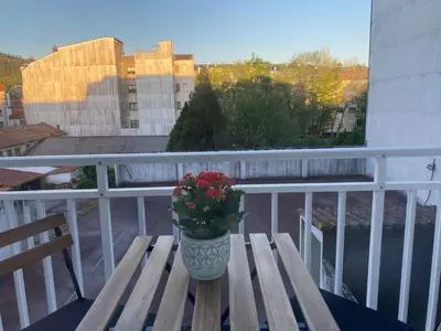 a vase of flowers sitting on a wooden bench on a balcony at A dos Pasos in Caldas de Reis