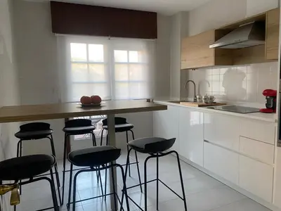 a kitchen with a counter and stools in it at A dos Pasos in Caldas de Reis