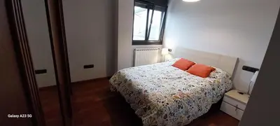 a bedroom with a bed with orange pillows on it at Apartamento El Puerto in Puerto de Vega